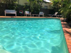 a swimming pool with blue water in a yard at Airport Clayfield Motel in Brisbane