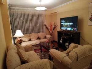 sala de estar con sofás y TV de pantalla plana. en Apartamento Exclusivo VIP en La Paz