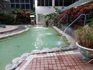 una piscina de agua con dos fuentes en 逸仙溫泉旅宿Yi-Shian Hotsprin House, en Wenquan