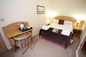 una camera d'albergo con letto e scrivania di Avon Causeway Hotel a Christchurch