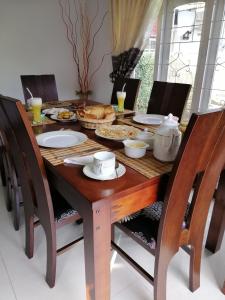 una mesa de madera con platos de comida. en Aerizo bungalow & Tours, en Nuwara Eliya