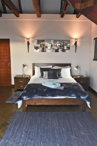 a bedroom with a large bed with two night stands at Hemel op Aarde Villa in Dwarskersbos