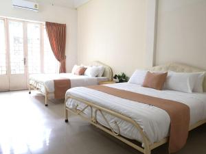 a bedroom with two beds and a window at Dutch Hosted B&B, ABC in Phnom Penh