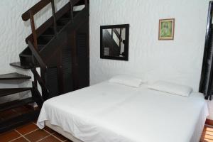 a bedroom with a white bed and a staircase at Casa Finca Corales Llano Grande 2 in Rionegro