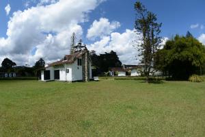 una vieja casa blanca en un campo de hierba en Casa Finca Corales Llano Grande 2, en Rionegro 8 fotos más
