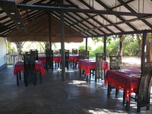a group of red tables and chairs in a pavilion at Beach Front Villa Nilaveli in Nilaveli