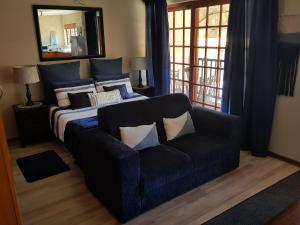 une chambre avec un lit, un canapé et un miroir dans l'établissement 4 You SELF-CATERING ACCOMMODATION, à Centurion 46 autres photos