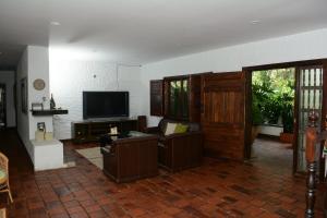 a living room with a couch and a television at Casa Finca El Embrujo in Rionegro