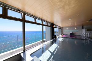 an indoor swimming pool with a view of the ocean at Vessel Hotel Campana Okinawa in Chatan