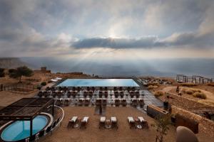 a view of a pool with tables and chairs at Beresheet by Isrotel Exclusive in Mitzpe Ramon