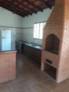 a kitchen with a brick oven in a room at Chácara Verava Ibiúna in Ibiúna