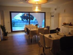 a dining room with tables and a large window at "CARA PACE" in collina - Guest House in Montefiore Conca