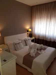 un dormitorio con una cama blanca con animales de peluche en Maxim en Palermo
