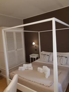 ein Schlafzimmer mit einem weißen Himmelbett und weißen Handtüchern in der Unterkunft Maxim in Palermo