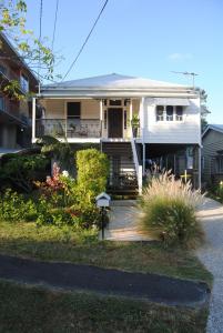 une maison blanche avec un jardin en face dans l'établissement Victoria 53, à Brisbane