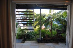 an open door to a garden with palm trees at Victoria 53 in Brisbane