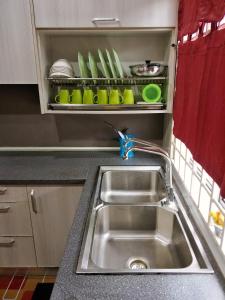 a kitchen with a sink and a shelf with dishes at Bunga Homestay Kelantan in Bachok +15 photos