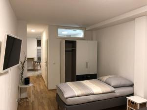 Un pequeño dormitorio con una cama y un televisor. en Apartment am Schloßplatz Erlangen, en Erlangen
