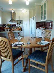 a kitchen with a wooden dining table and chairs at 201Waimumu in Gore