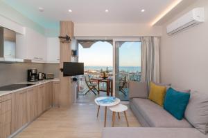 a living room with a couch and a kitchen with a view at Eolia Apartment in Zakynthos Town