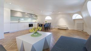 a living room with a white table and a kitchen at Great apartament in a heart of Tallinn in Tallinn