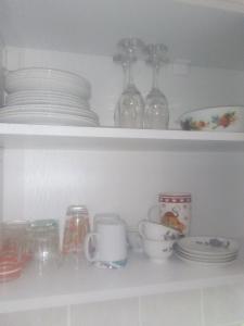 une étagère avec des assiettes, des tasses et de la vaisselle dans l'établissement Ivana Center, à Novi Sad