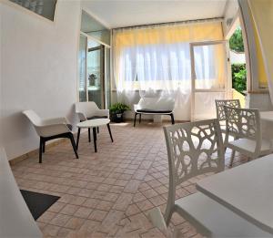a room with chairs and a table and a window at Residence Riviera in Alba Adriatica
