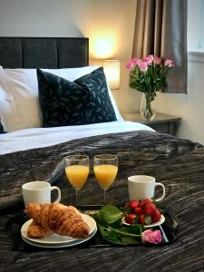 a breakfast tray with croissants and fruit on a bed at Central Apartment Linlithgow in Linlithgow