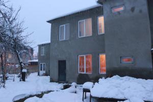 ein Haus mit Schnee davor in der Unterkunft Inga Jafaridze Guesthouse Pele in Mestia