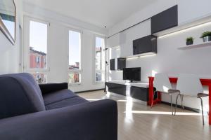 un soggiorno con divano, tavolo e sedie di Casa da Suite Idea a Milano