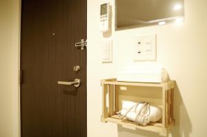 a bathroom with a door and a shelf with towels at Hotel Cocoro Inn Asakusa Kuramae in Tokyo +125 photos