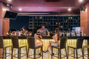 a group of people sitting at a bar at Acqua Hotel in Pattaya Central