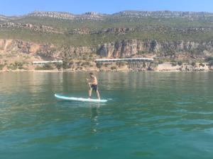 a man standing on a surfboard in the water at Casa dos Avós in Villa Nogueira