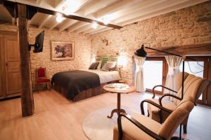 a bedroom with a bed and a brick wall at Les Chambres du Chat in Sainte-Cécile