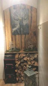 eine Wand mit einem Gemälde eines Hirsches und einem Stapel Holzstämme in der Unterkunft Gasthaus Schützen in Hornberg