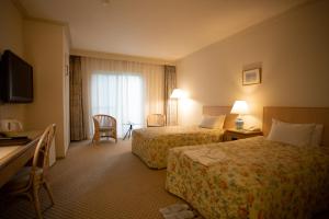 um quarto de hotel com duas camas e uma janela em Kyu Karuizawa Hotel Otowa No Mori em Karuizawa