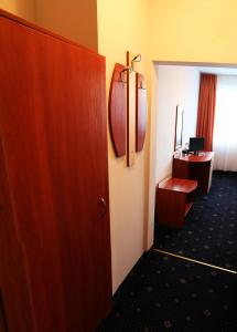 eine Tür zu einem Hotelzimmer mit einem Schreibtisch und einem Zimmer in der Unterkunft Hotel Rahovets in Gorna Orjachowiza