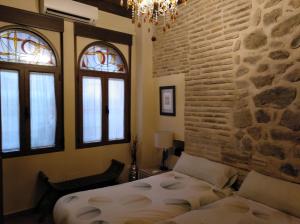 トレドにあるApartamentos La Casa Del Grialのベッドルーム1室(ベッド1台、窓2つ付)