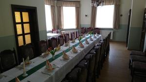 a long table in a room with tables and chairs at Pension Erbgericht in Großhartmannsdorf
