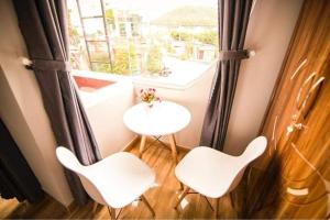 um quarto com uma mesa e duas cadeiras e uma janela em SUNNY HOTEL em Quy Nhon