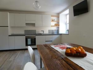 una cocina con una mesa de madera con naranjas. en Casa Lassù, en Carano