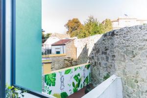 ポルトにあるAPOSENTUS - Your Home at Pinheiro's Studioの窓から石垣の景色を望む