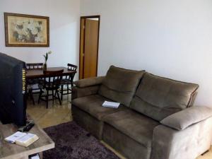 - un salon avec un canapé brun et une table dans l'établissement Casa conforto, à Lavrinhas