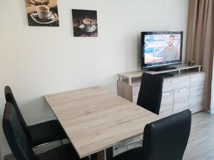 une salle à manger avec une table en bois et une télévision dans l'établissement Ferienwohnung Harzlust, à Goslar