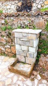 a stone block wall with aestone step in front of a building at Stone house on the rock in Lílaia