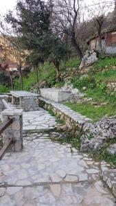 a stone walkway with a bench and a stone path at Stone house on the rock in Lílaia