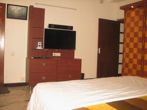 Atithi Comfort Homes (Exclusively for families) - Royal في فيساخاباتنام: غرفة نوم مع سرير وتلفزيون في خزانة