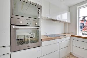 a kitchen with white cabinets and a microwave at CITY LUX APARTM, 2 FULL BATHROOMs, 3v in Copenhagen