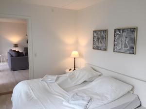 a white bed in a white bedroom with a lamp at CITY LUX APARTM, 2 FULL BATHROOMs, 3v in Copenhagen
