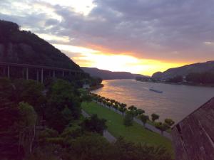 a view of a river at sunset with a bridge at Parkhotel "Am Schänzchen" in Andernach